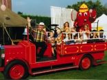Martin and children on a vintage fire engine at a gala